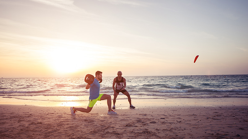 a man holding a ball on a beach