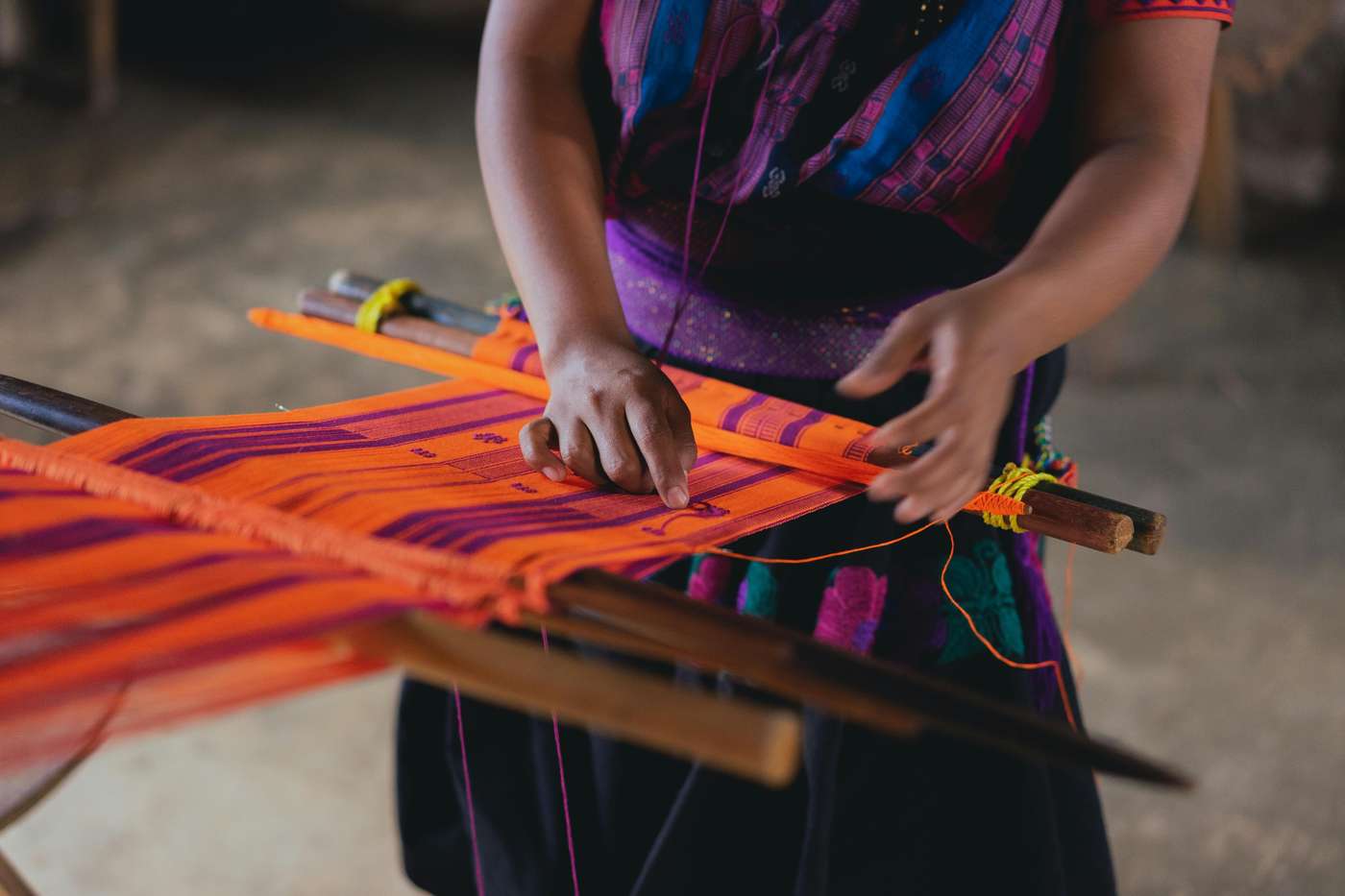 Close-up of traditional Mexican weaving with vibrant textiles on a wooden loom.