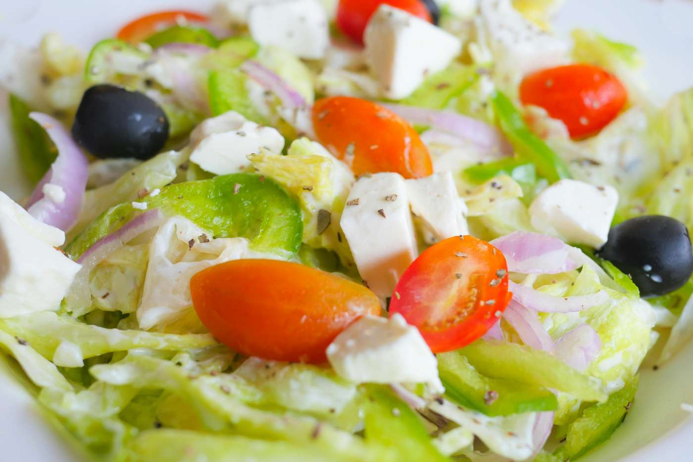 Close-up of a vibrant Greek salad featuring feta cheese, tomatoes, and olives.