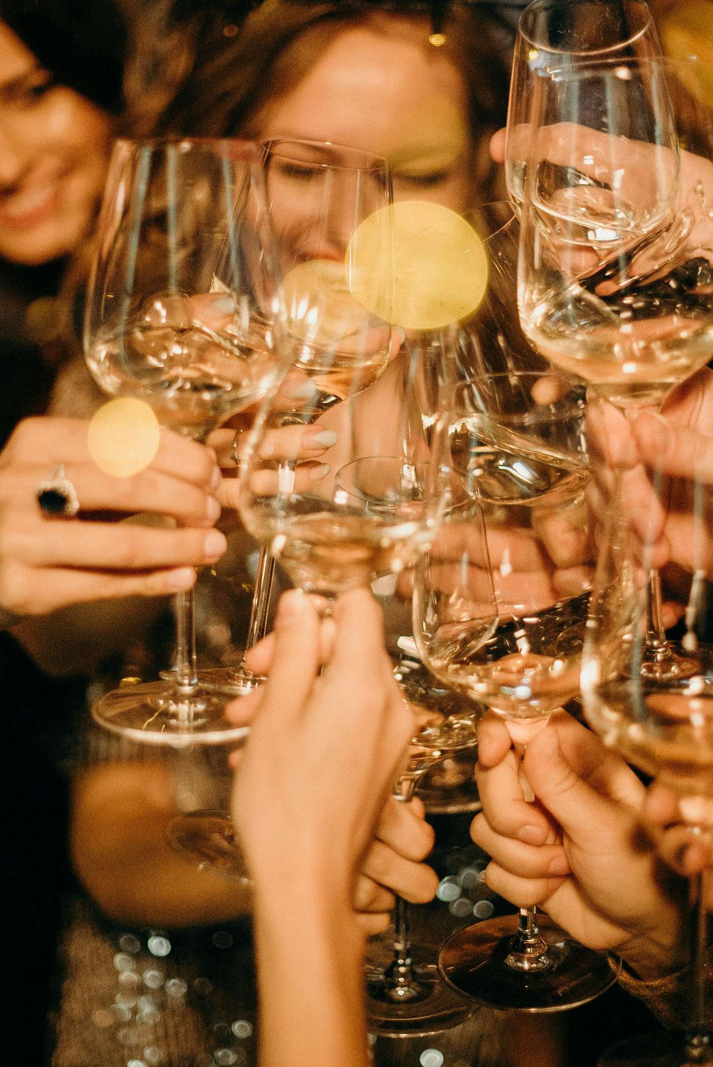 Group of people toasting with champagne glasses during a festive New Year's Eve party.