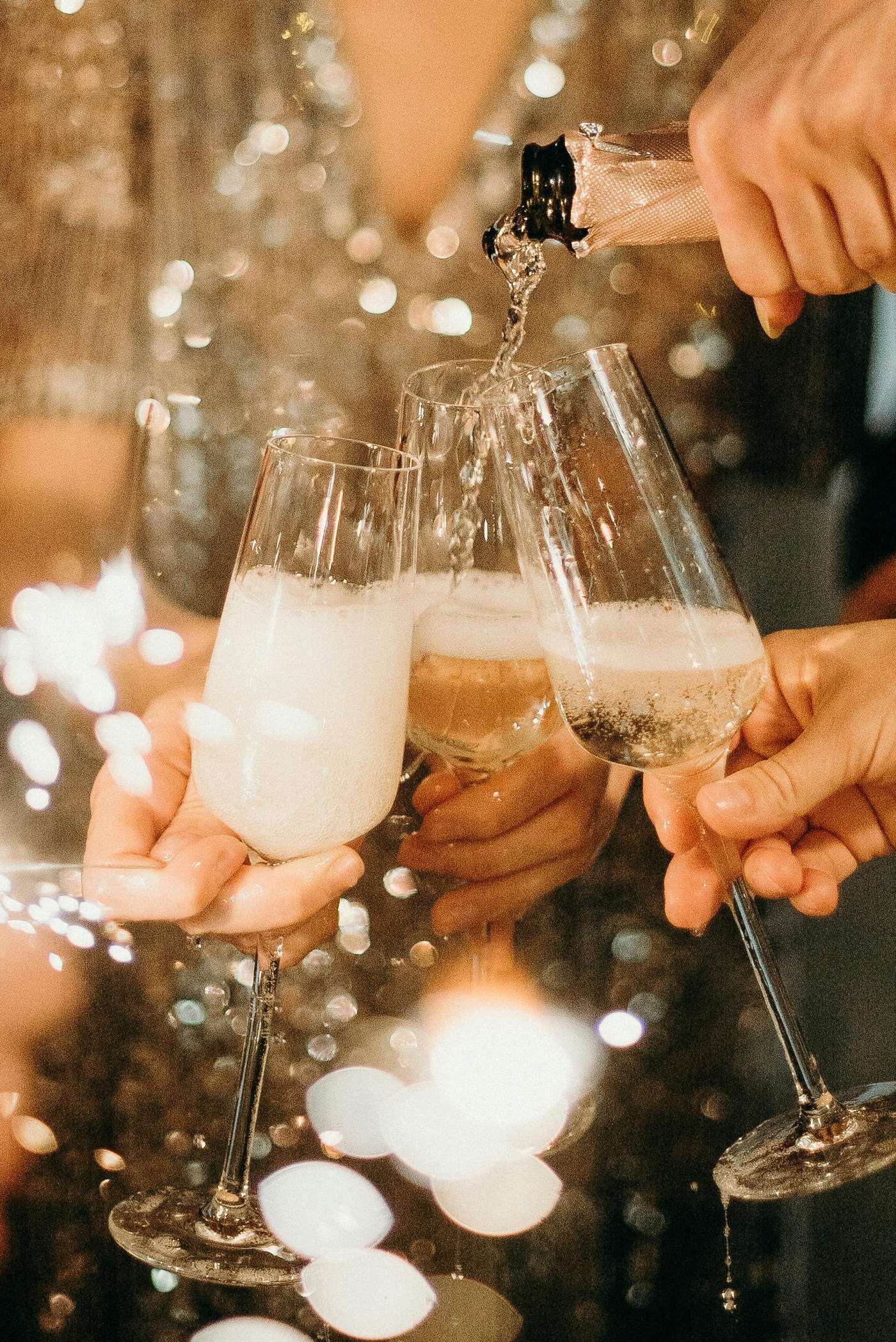 People toasting with champagne glasses amidst sparklers at a festive party.