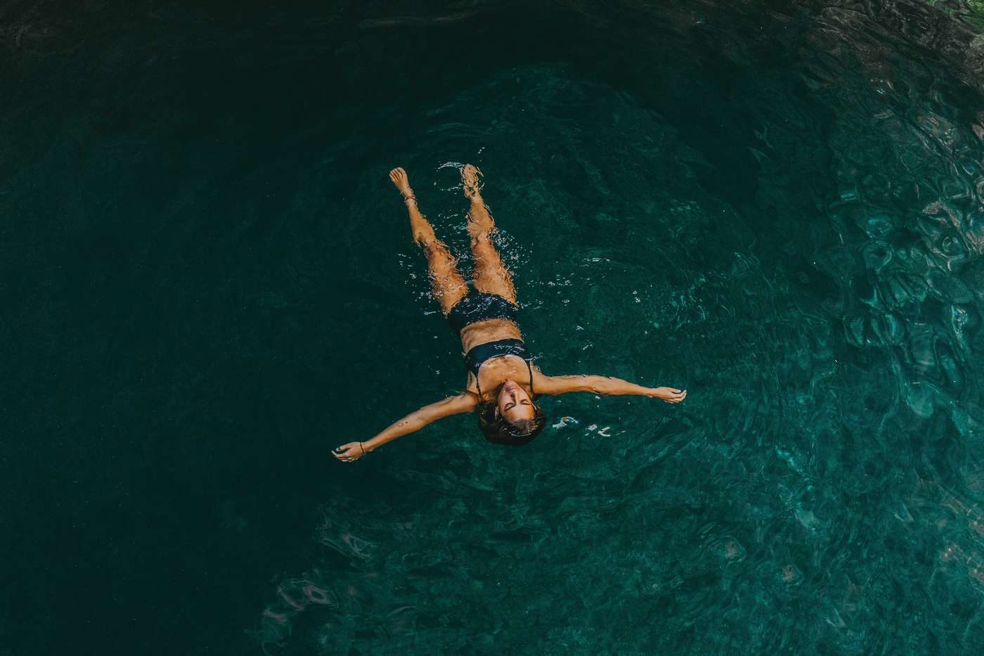 woman in black bikini swimming in water