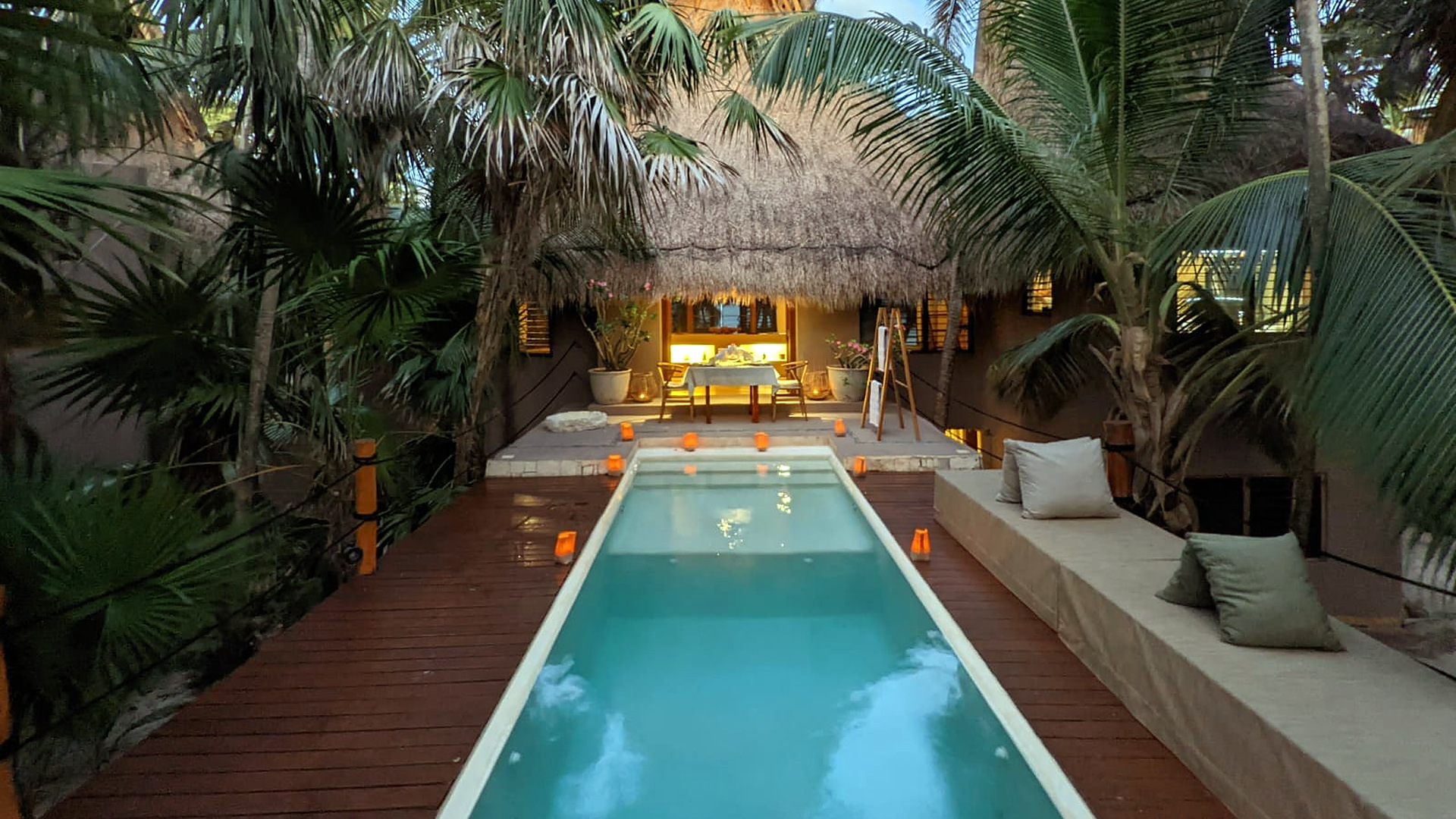 The candlelit pool and day bed under the palms at Casa Nalum at dusk, Sian Ka'an, Tulum