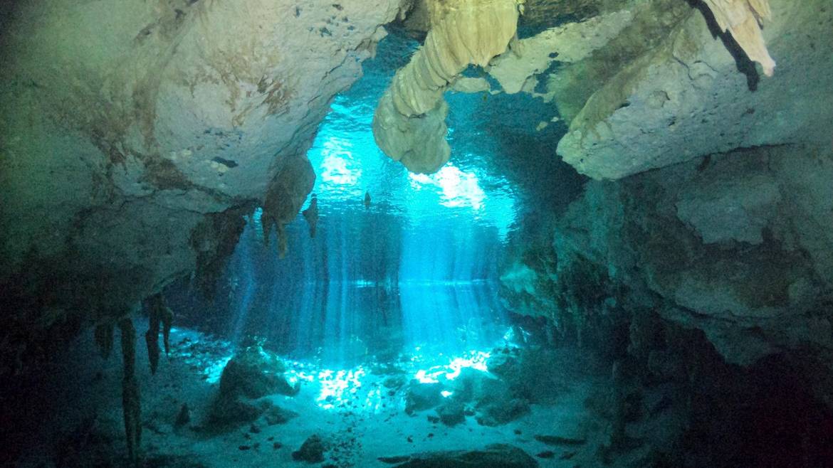 Light beams through the water at Cenote Dos Ojos