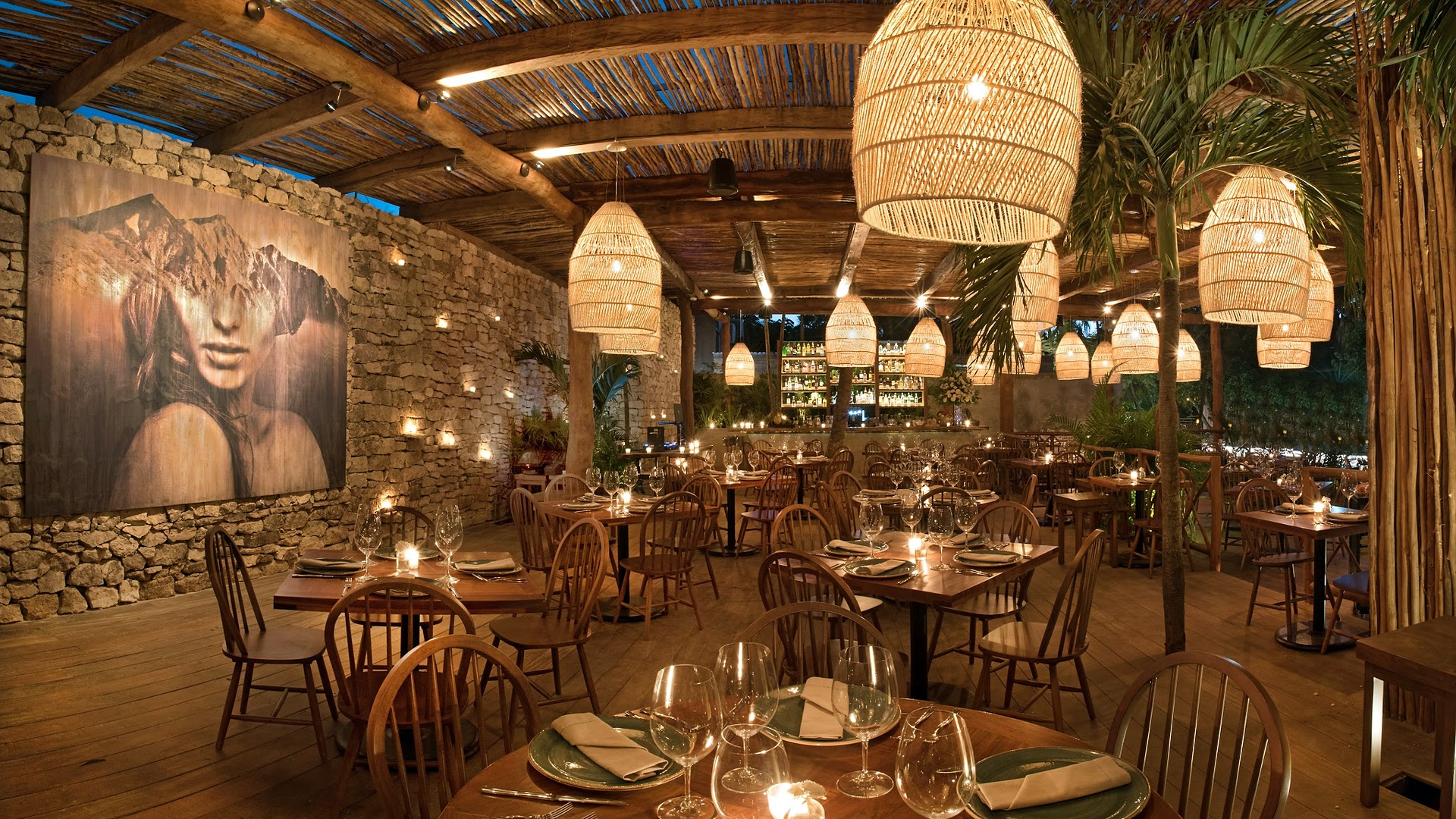 The dining room at RosaNegra in Tulum lit by woven pendant lamps